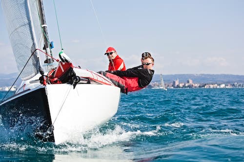 A team on a sailboat leans with the turning of the boat