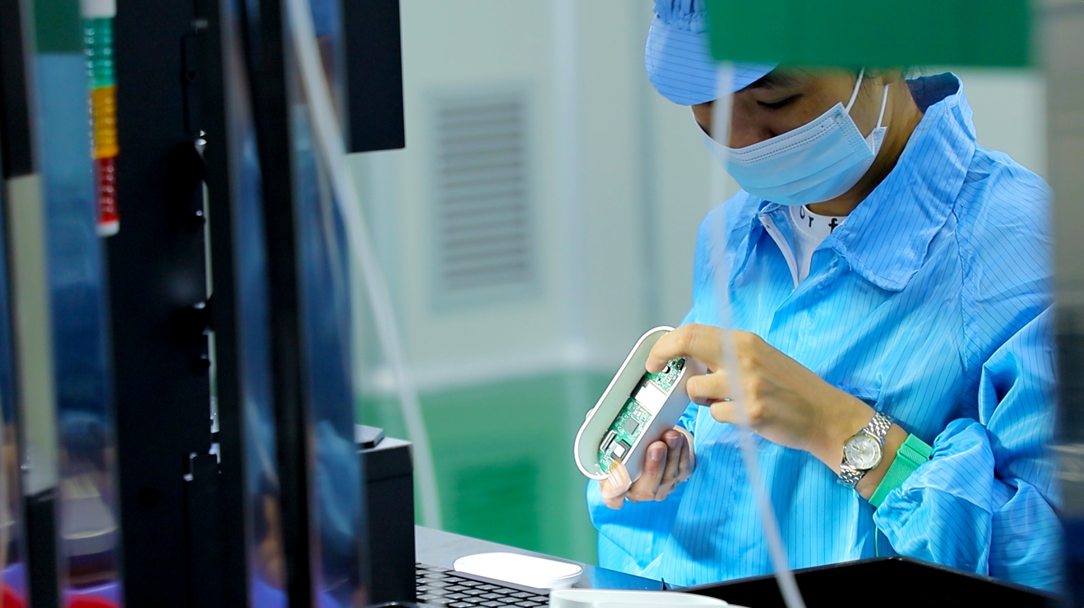 Man inspecting an electronic device in a factory